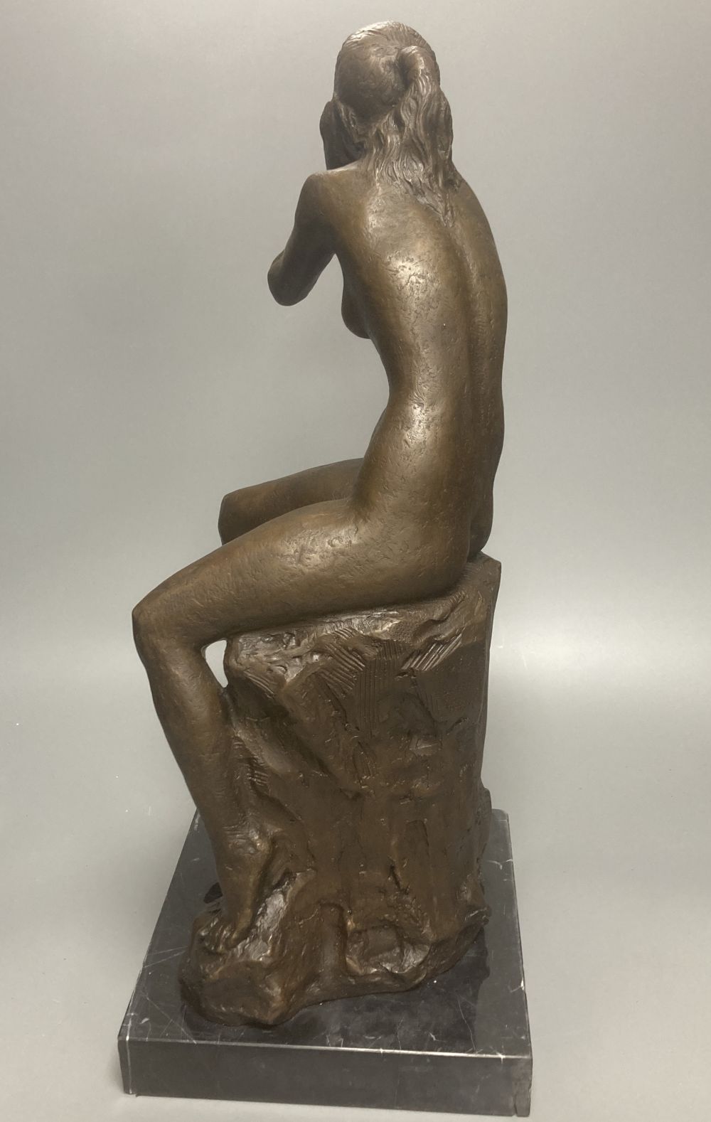 A bronze model of a seated female nude, indistinctly signed Silk, on marble plinth, 52cm
